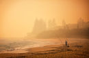 A lone fisherman in bushfire haze at Caloundra, Queensland