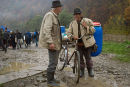 Two men in traditional clothes chat at the market, Dragomiresti, Maramures, Romania