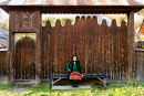 Woman in traditional clothes sitting outside her home, Maramures, Romania